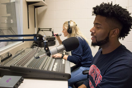 Communications Studio with students talking into microphones
