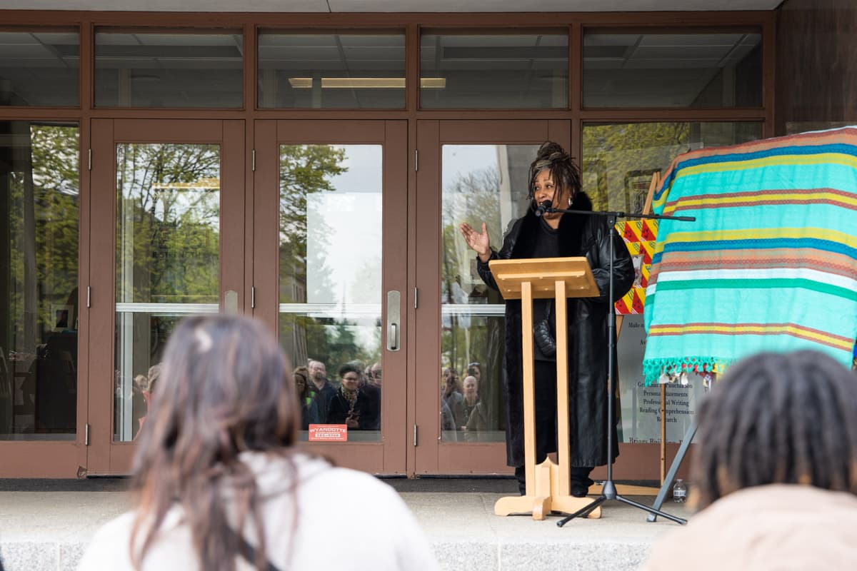 Carole Morisseau speaking in front of a group of people during the Healing Wall Panel 5 unveiling