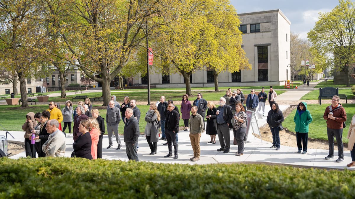 people on McNichols Campus grouped in front of a group during the Healing Wall Panel 5 unveiling