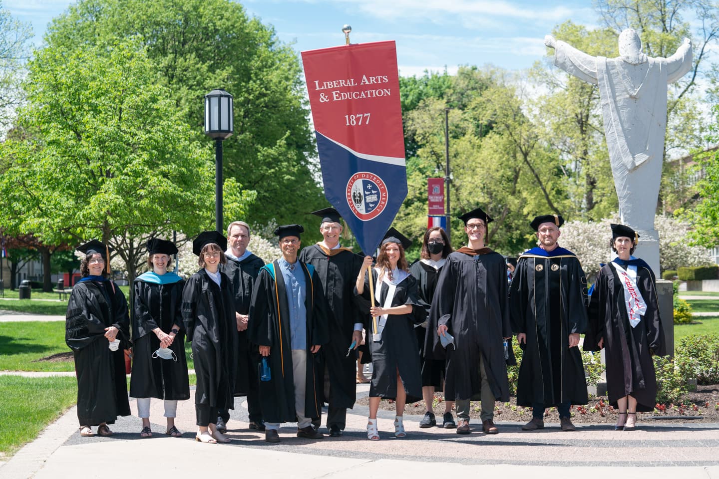 College of Liberal Arts & Education faculty and banner bearer ready for the 2022 Commencement ceremony